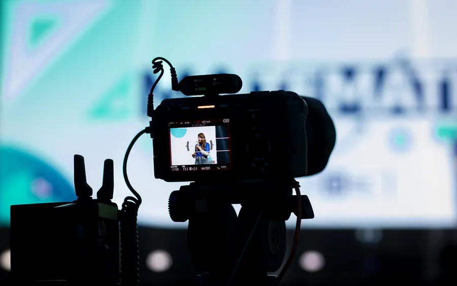 Camera recording in 4K during the broadcast, speaker visible in the viewfinder