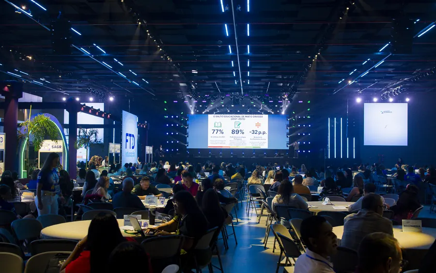 Full room watching the screen fed by the live broadcast